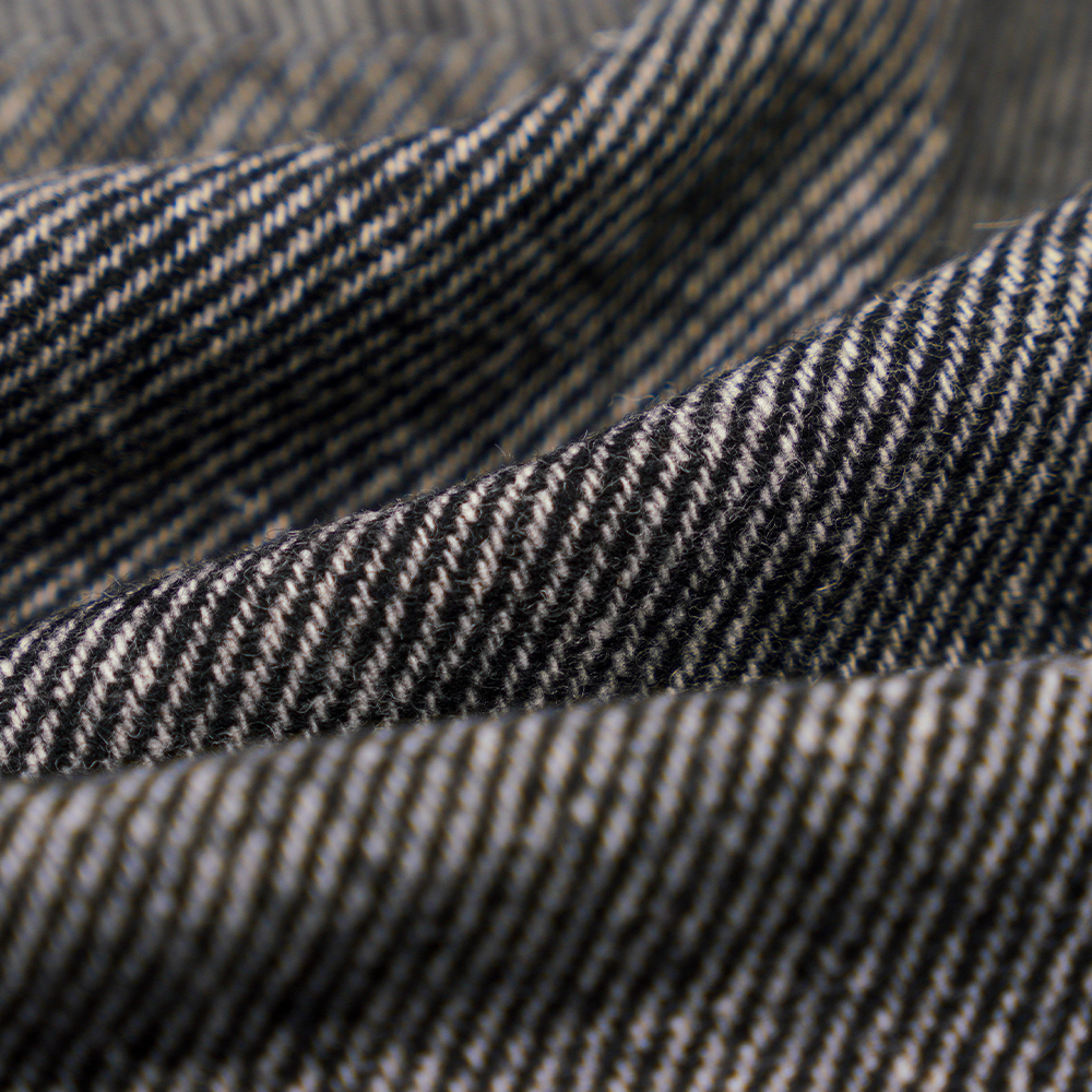 50 % Wolle, 30 % Polyester, 20 % andere Fasern, 320 g/m, gebrochenes Weiß + Schwarz, Twill-Flanellstoff, ML-C-22104